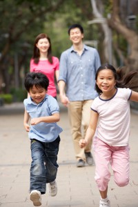 Chinese Family Walking Through Park With Running Children