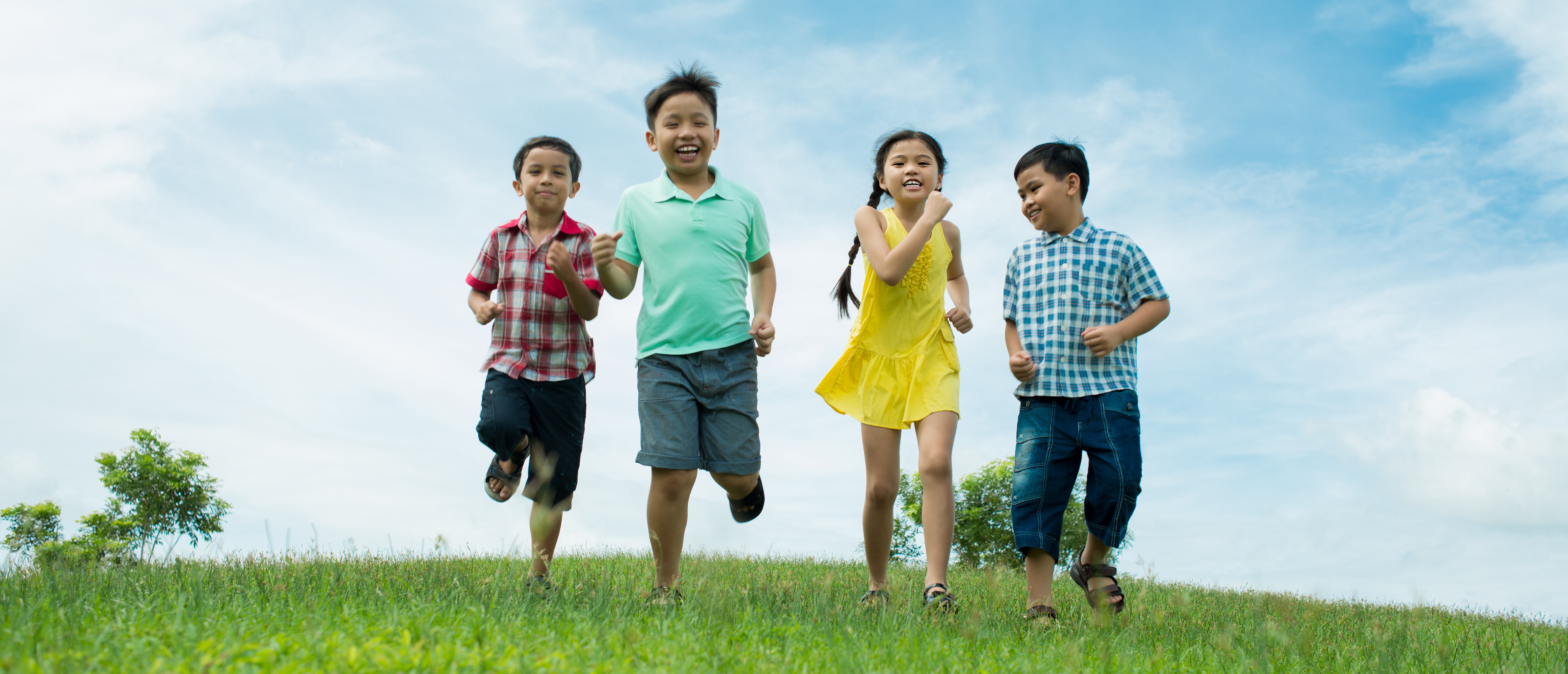 Cheerful kids running across the meadow