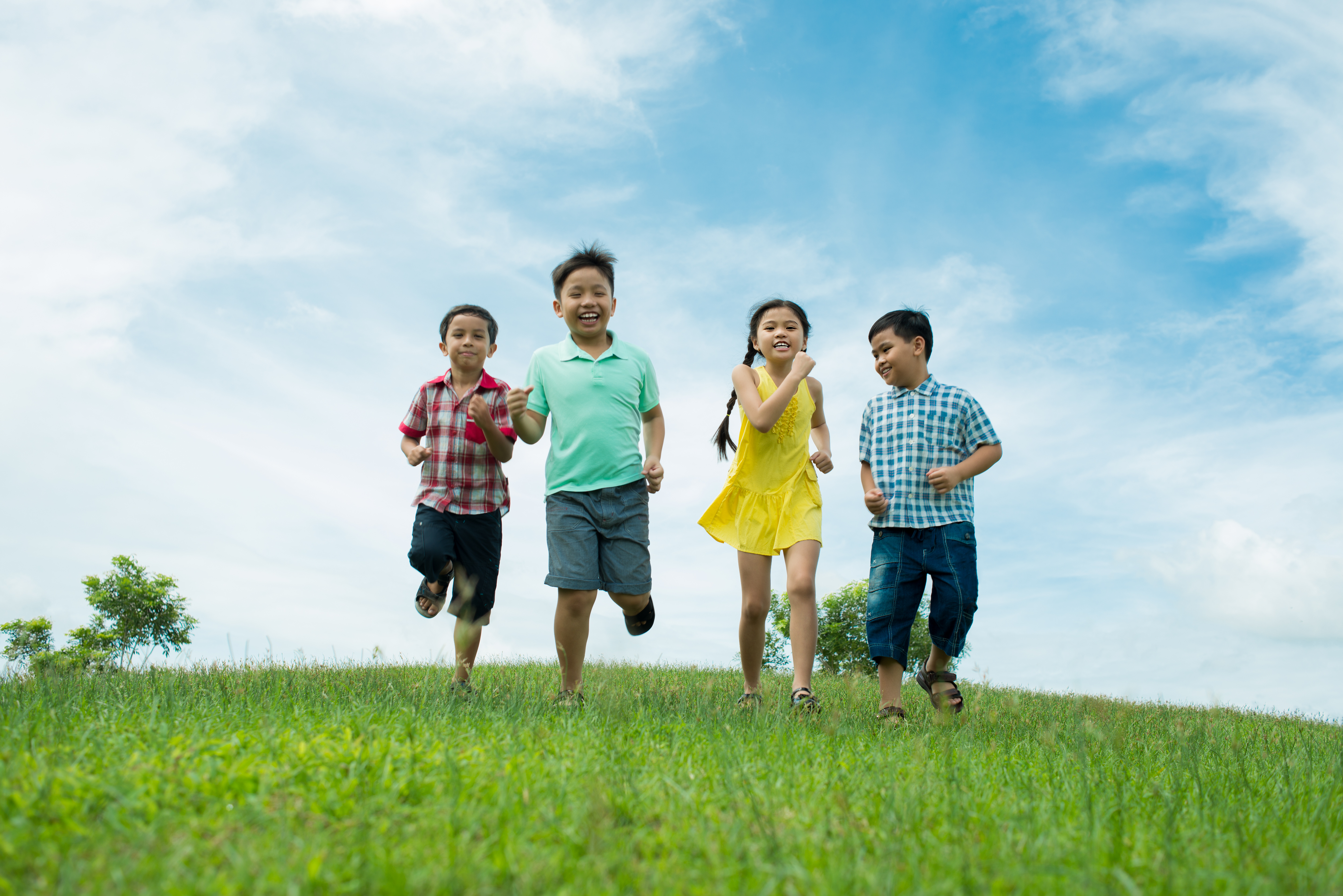 Cheerful kids running across the meadow