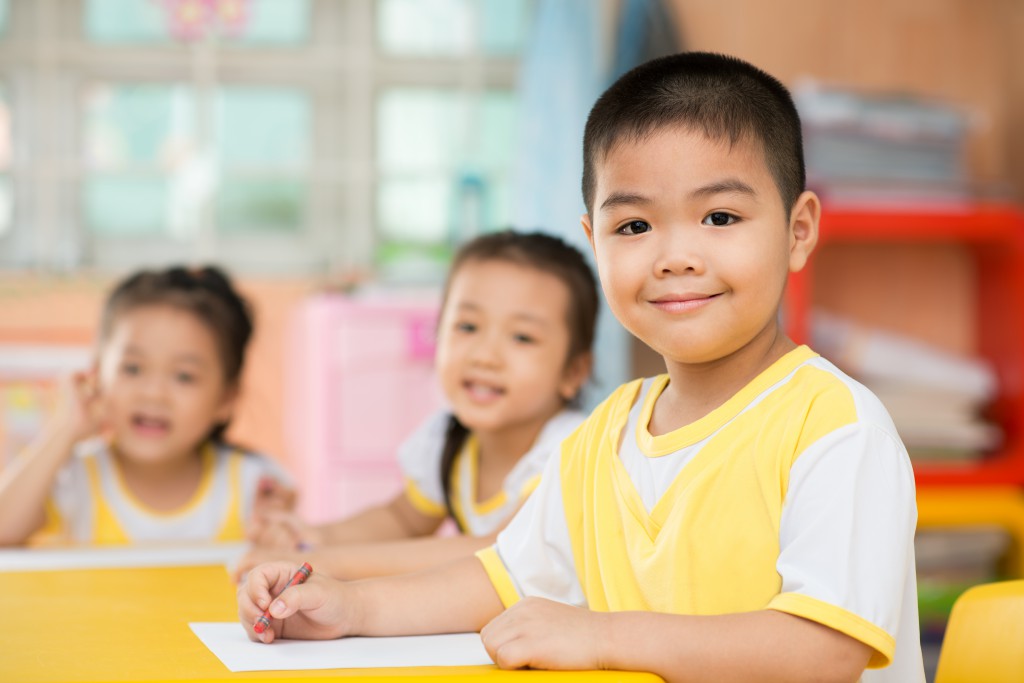 Two girls and a boy sitting behind the desk