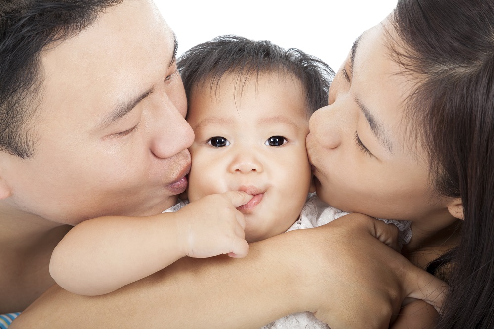 Happy family kissing the baby