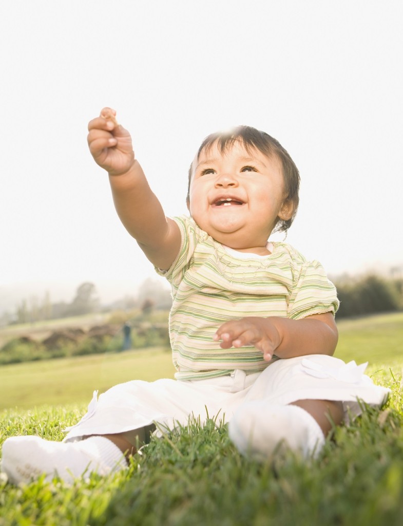 Asian baby sitting in grass