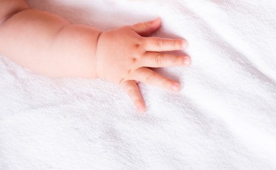 close-up-hand-little-baby-bed-background_85574-8732