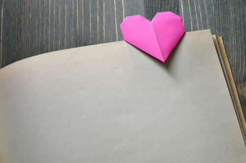 Pink Bookmark a heart of origami. Background for design on Valentine's Day